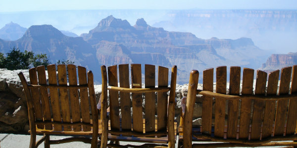 Wooden chairs overlooking rocky outcrops of the top of the Grand Canyon