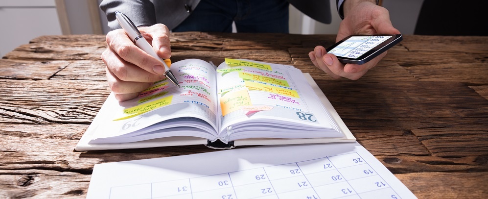 Businessperson Writing Schedule In Diary