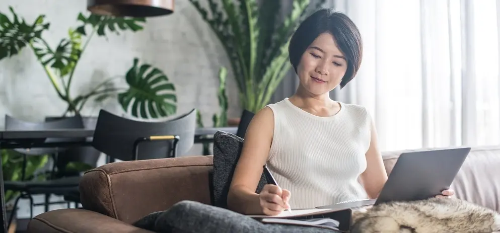 Happy Asian Woman Using The Computer At Home.