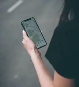 Hand holding cell phone with map displayed