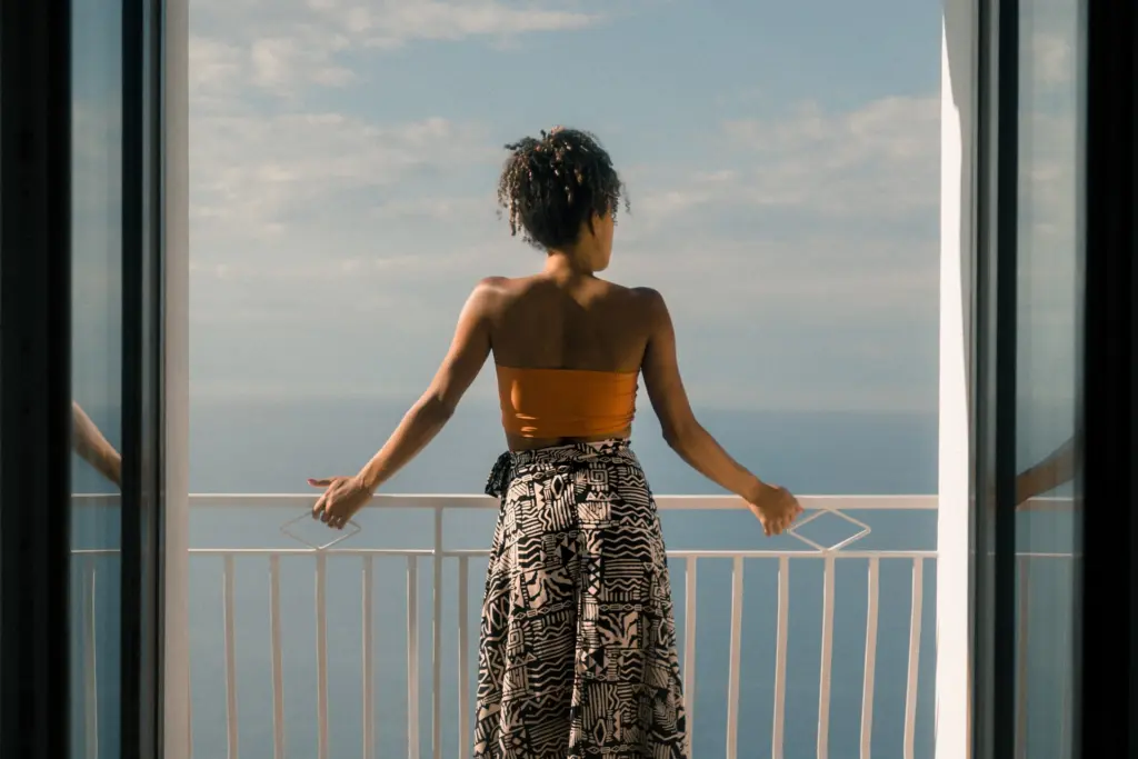 Woman on balcony overlooking the ocean