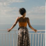 Woman on balcony overlooking the ocean