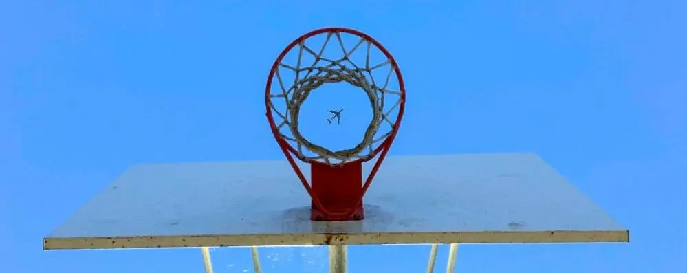 Airplane viewed through basketball hoop