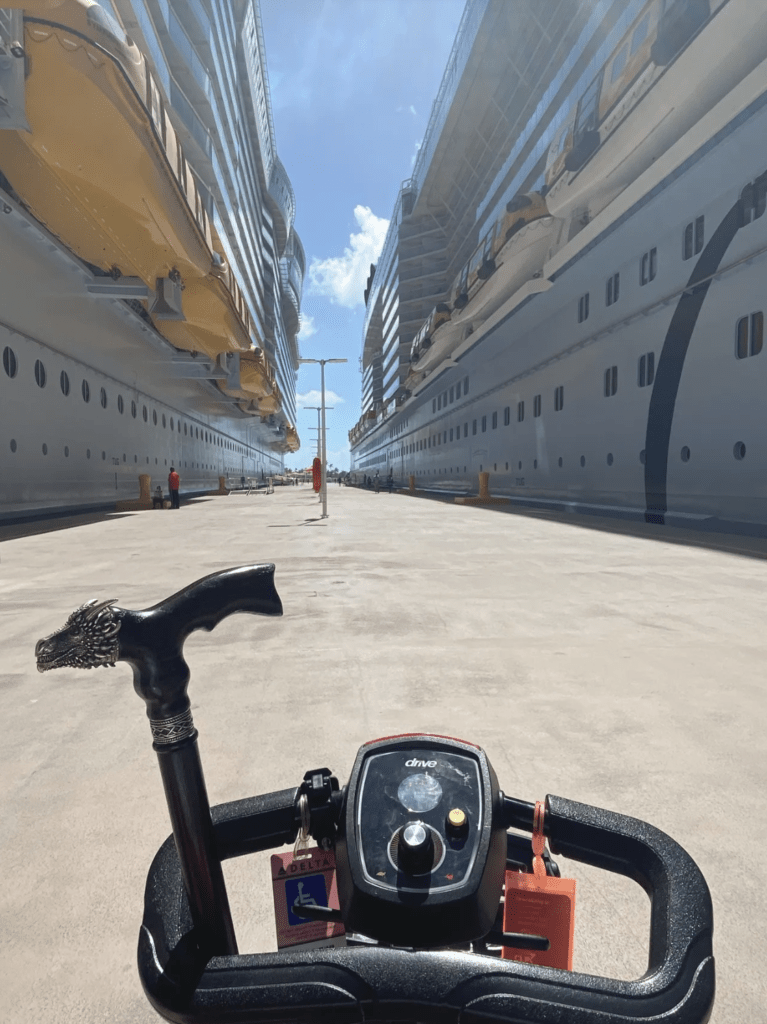 Mobility scooter in port in between two large cruise ships