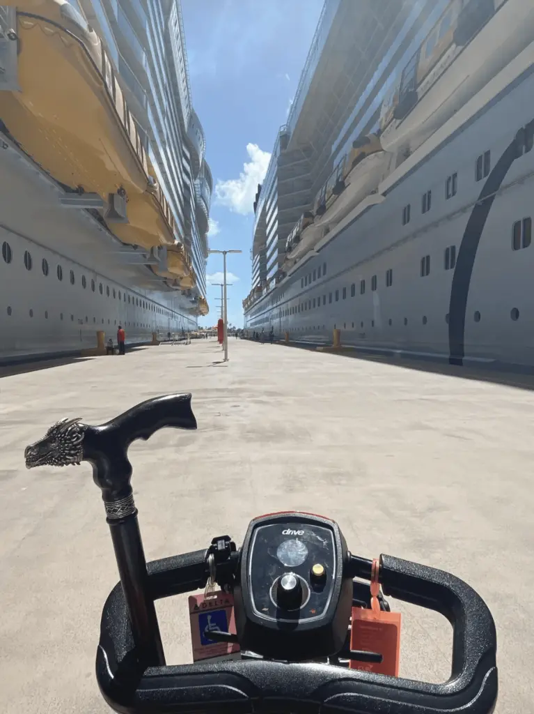 Mobility scooter in port in between two large cruise ships