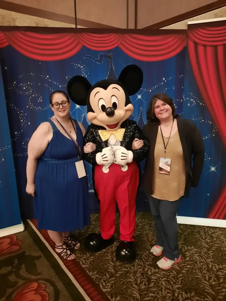 Sara and friend posing with Mickey at Disneyland