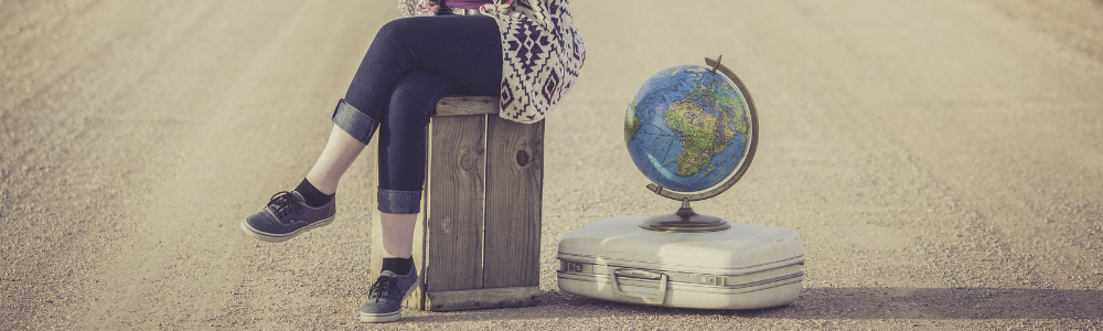 Person Sitting Next To Suitcase Globe