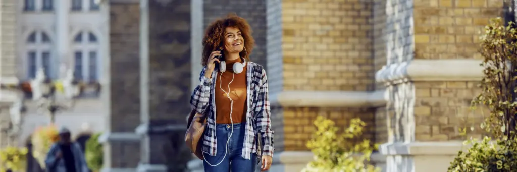 Woman With Headphones Walking On Street